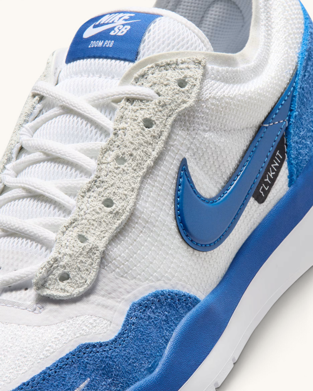 Detalle de tenis FRIDAY.COM.CO Nike SB PS8 en blanco y azul con tejido Flyknit, cuero y logo lateral