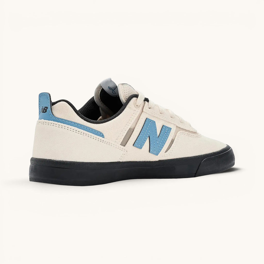 Tenis New Balance Numeric 306 color marfil con detalles en azul claro y suela negra. Zapatilla de skate de ante y malla.