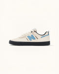 Tenis New Balance Numeric 306 Sea Salt/Black de ante y malla con logo N azul y suela negra.
