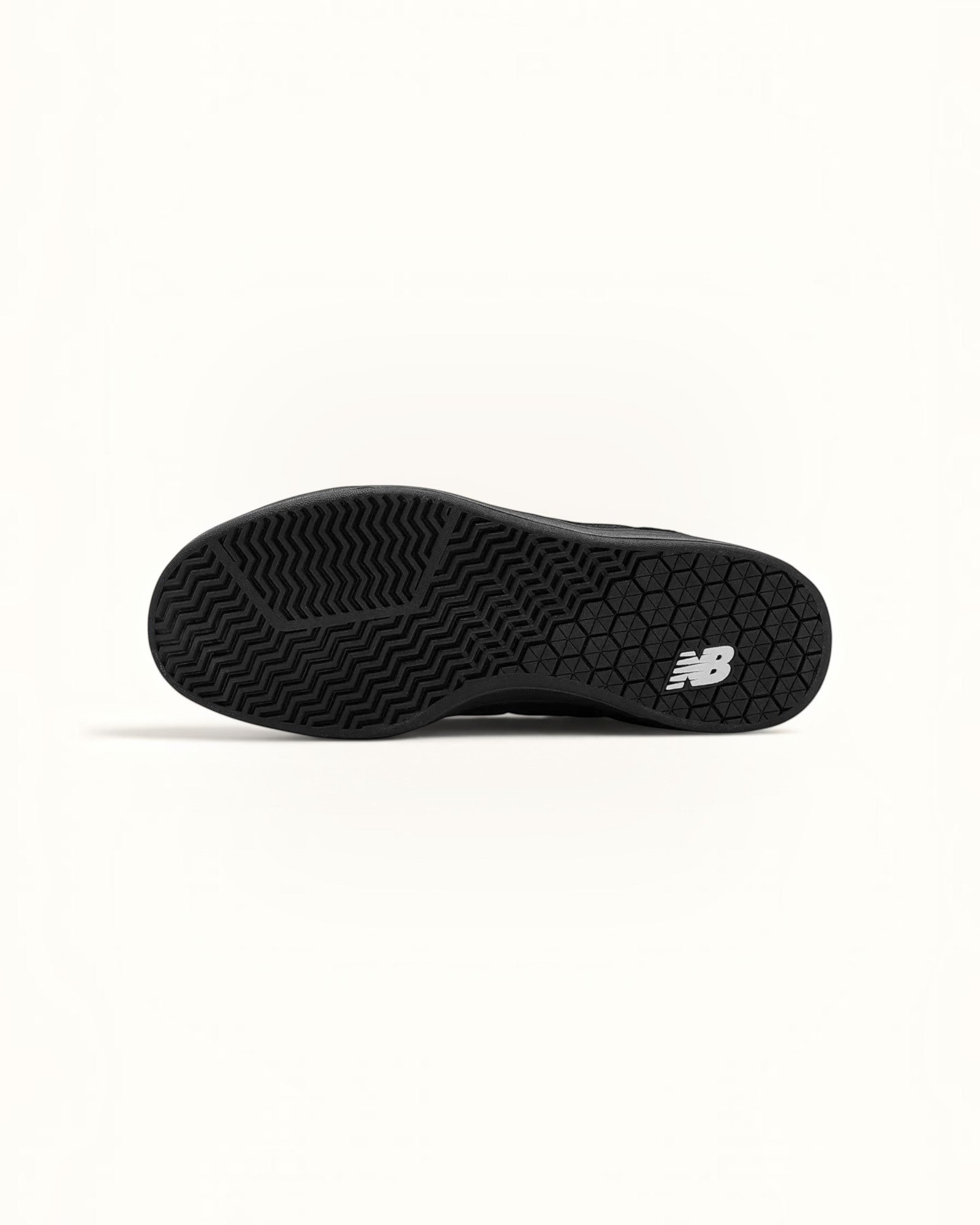 Suela de goma negra de los tenis New Balance Numeric 440, con patrón de espiga y logo NB.