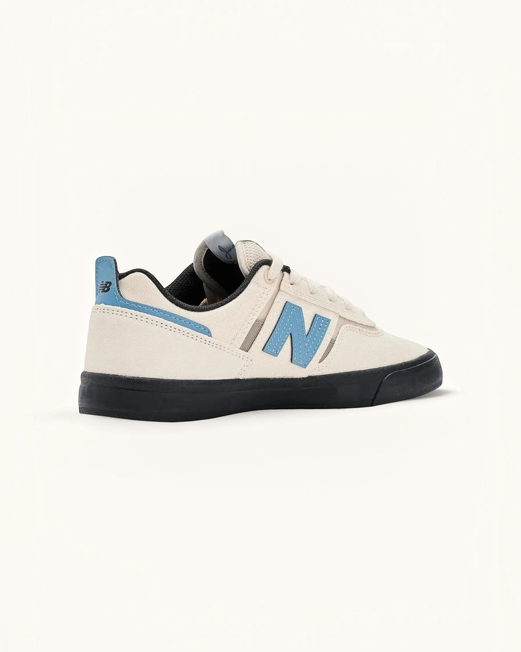 Tenis New Balance Numeric 306 color marfil con detalles en azul claro y suela negra. Zapatilla de skate de ante y malla.