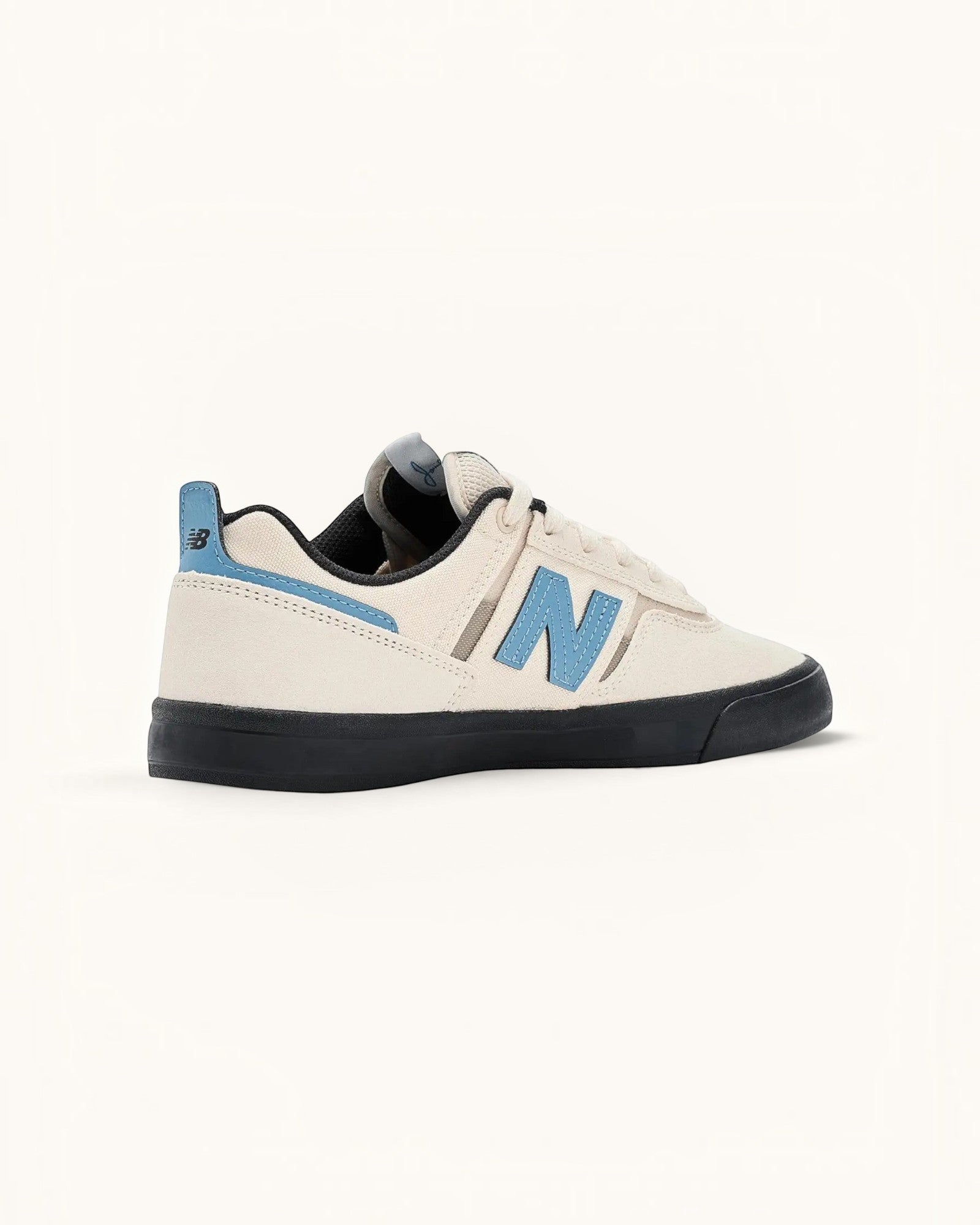 Tenis New Balance Numeric 306 color marfil con detalles en azul claro y suela negra. Zapatilla de skate de ante y malla.